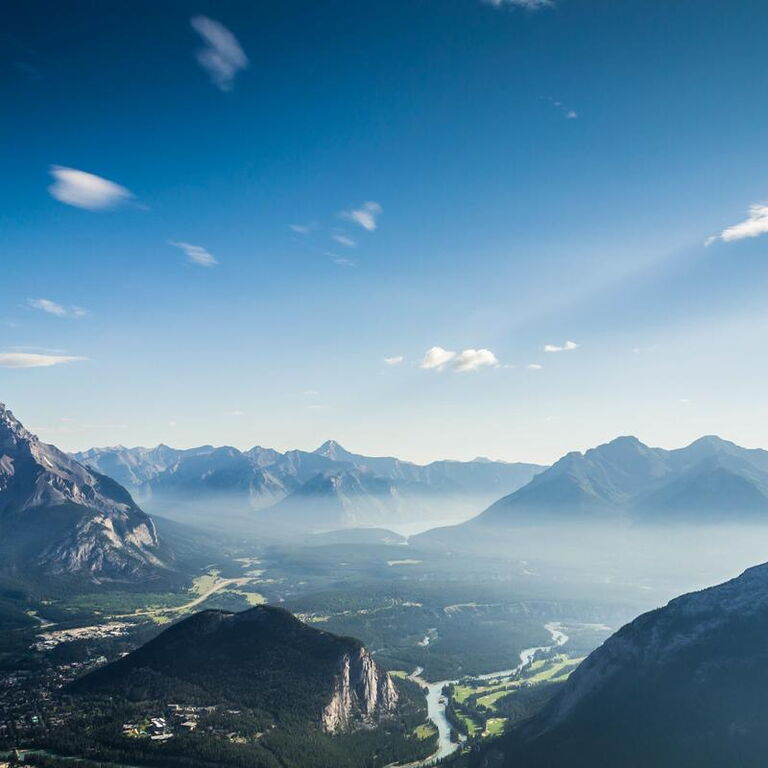 Ein bläuliches Bergpanorama mit einem großen Tal und einem Fluss