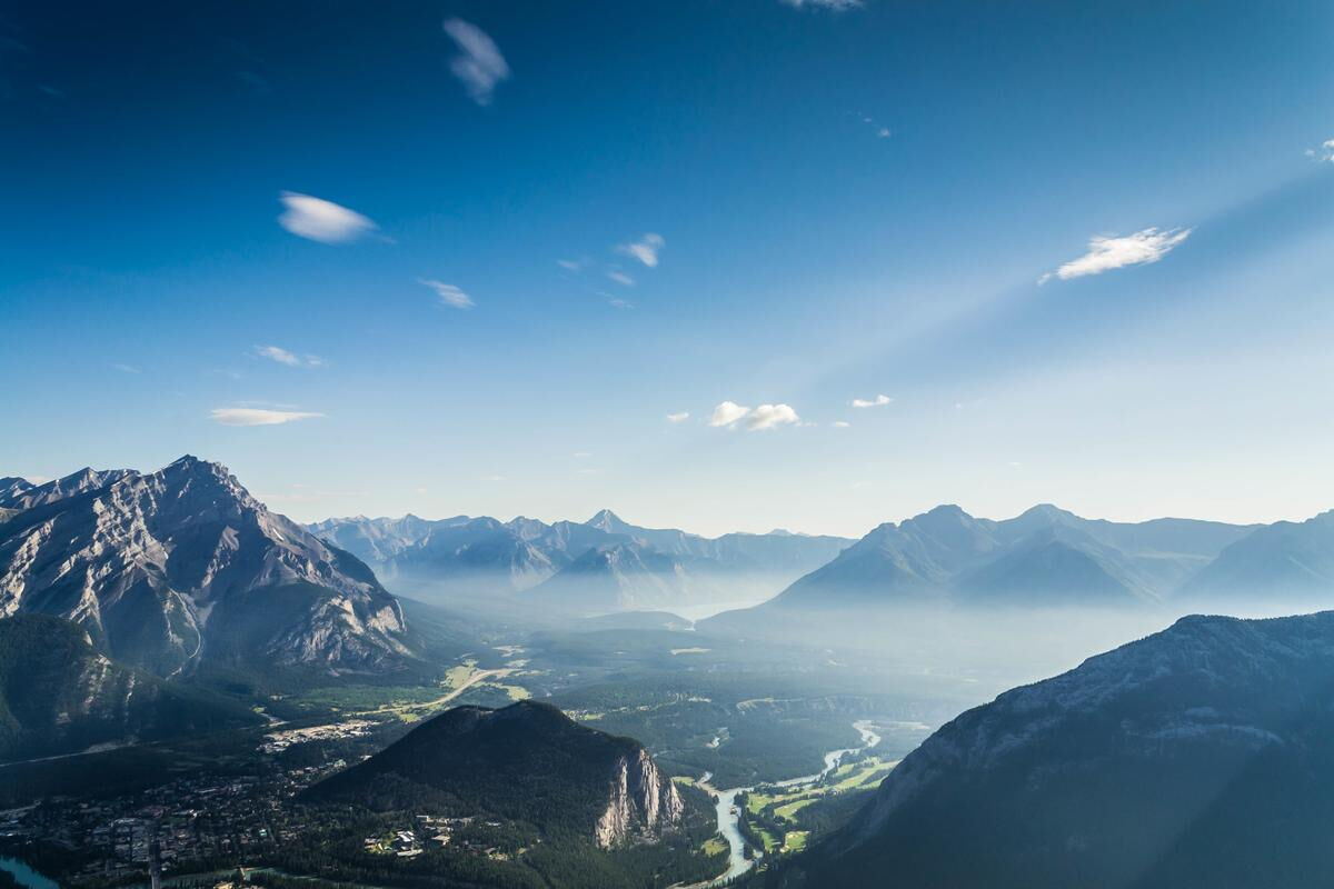 Ein bläuliches Bergpanorama mit einem großen Tal und einem Fluss